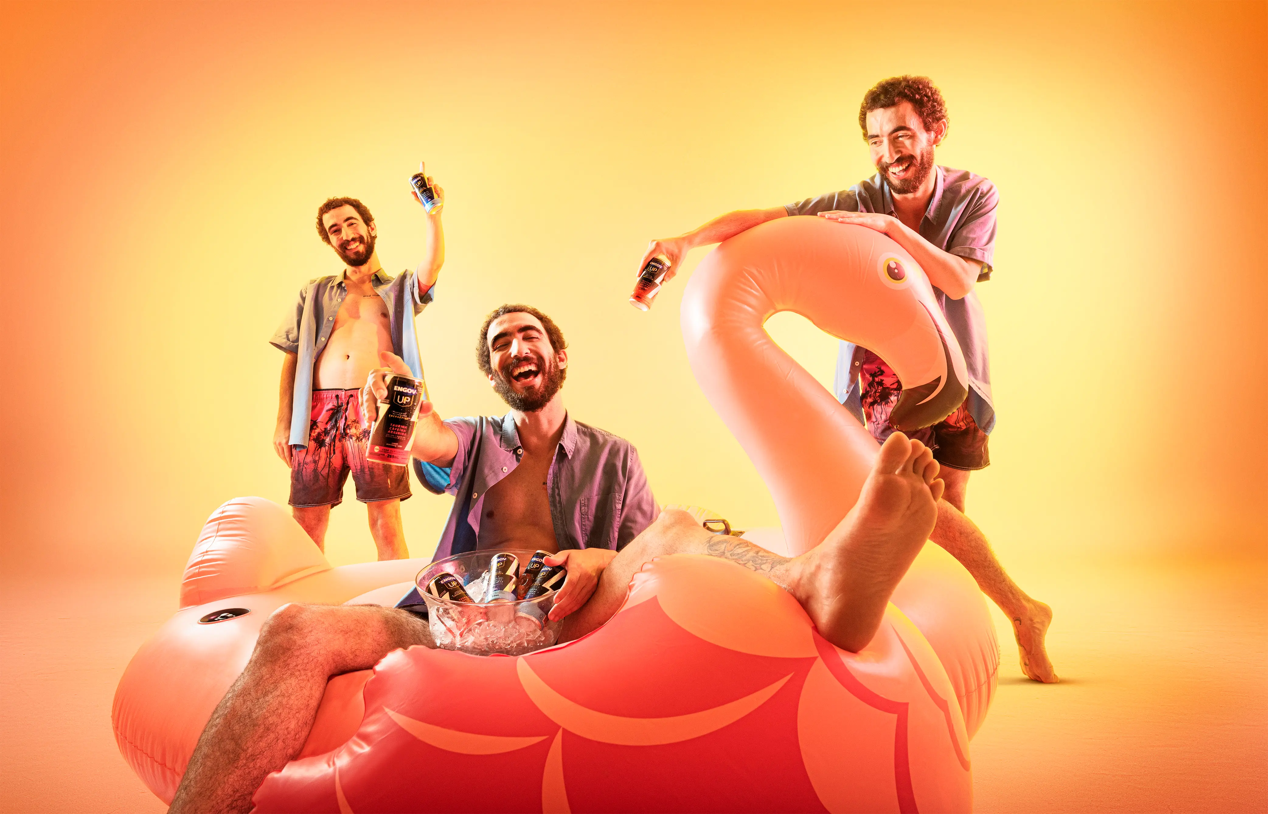 Homem branco sorrindo com uma lata de Engov Up na mão sentado em uma boia no formato de cisne.